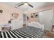 Bedroom with a black and white striped bedspread, complemented by a vanity desk and a heart-shaped mirror at 14524 Huntingfield Dr, Orlando, FL 32824