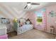bedroom with pink chevron striped accent wall and a cozy bed filled with plush toys at 14524 Huntingfield Dr, Orlando, FL 32824