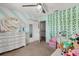 Stylish bedroom with striped walls, a white dresser, and a cozy bed filled with plush toys at 14524 Huntingfield Dr, Orlando, FL 32824
