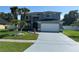 Charming two-story home featuring a spacious driveway, attached garage, and tropical landscaping at 14524 Huntingfield Dr, Orlando, FL 32824
