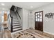 Inviting foyer with wood-look tile flooring, staircase, and stylish front door at 14524 Huntingfield Dr, Orlando, FL 32824