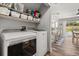Laundry room with modern appliances, open shelving, and easy access to kitchen, bar and outdoor pool at 14524 Huntingfield Dr, Orlando, FL 32824