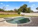 Beautiful kidney-shaped pool and spa with brick paved patio and grassy yard at 14524 Huntingfield Dr, Orlando, FL 32824