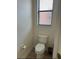 Bathroom features a toilet and a window with blinds, offering natural light and privacy at 152 Glendale Ct, Kissimmee, FL 34759