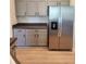 Close up of kitchen with stainless steel refrigerator and gray lower cabinets at 152 Glendale Ct, Kissimmee, FL 34759