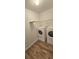 Clean laundry room with wood-look floors, a wire shelf, and washer and dryer units at 1588 Diamond Loop Drive, Kissimmee, FL 34744