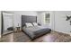 Modern bedroom features a large bed, wood-look floors, and a full-length mirror at 15888 Ne 152Nd Ave, Fort Mc Coy, FL 32134
