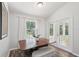 Cozy dining area featuring a dark wood table, white curtains, and natural light from windows and glass doors at 15888 Ne 152Nd Ave, Fort Mc Coy, FL 32134