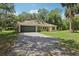 Inviting single-story home featuring a two-car garage and a gravel driveway surrounded by a lush green lawn at 15888 Ne 152Nd Ave, Fort Mc Coy, FL 32134