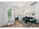 Bright living room with modern furniture, hardwood floors, and large windows with white curtains at 15888 Ne 152Nd Ave, Fort Mc Coy, FL 32134