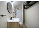 Modern bathroom featuring a sleek vanity, round mirror, and walk-in shower at 17927 E Apshawa Rd, Minneola, FL 34715