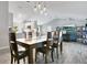 Dining room with a long wooden table, chairs, hanging pendant lights, and connecting rooms at 17927 E Apshawa Rd, Minneola, FL 34715