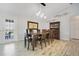 Dining room with a long wooden table, chairs, hanging pendant lights, and a view to the pool at 17927 E Apshawa Rd, Minneola, FL 34715