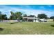 Charming home featuring a well-manicured lawn, mature trees, and ample parking space at 17927 E Apshawa Rd, Minneola, FL 34715