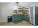 Charming kitchen with green cabinets, wood countertops, open shelving, and stainless steel refrigerator at 17927 E Apshawa Rd, Minneola, FL 34715