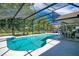 Relaxing screened-in pool area with a clear blue pool, outdoor dining, and lounge chairs at 17927 E Apshawa Rd, Minneola, FL 34715