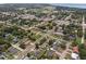 An aerial view of a quiet neighborhood with mature trees and well-maintained homes near a large lake at 203 E Lakeview Ave, Eustis, FL 32726