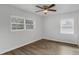 Bright bedroom with two windows, ceiling fan, and wood-look flooring at 203 E Lakeview Ave, Eustis, FL 32726