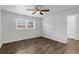 Neutral bedroom with ceiling fan, window and wood-look flooring at 203 E Lakeview Ave, Eustis, FL 32726