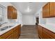 Open kitchen with stainless steel appliances, wood cabinets, and a view into the living area at 203 E Lakeview Ave, Eustis, FL 32726