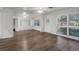 Bright living area features modern wood-look floors, white walls, large windows, and white trim at 203 E Lakeview Ave, Eustis, FL 32726