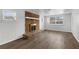 Living room featuring a stone fireplace, neutral walls, new wood flooring, and a large window at 203 E Lakeview Ave, Eustis, FL 32726