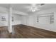 Spacious living area featuring wood-look flooring, white wainscoting, and a built-in shelving unit at 203 E Lakeview Ave, Eustis, FL 32726