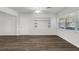 Open living space with wood-look floors, white wainscoting, a built-in shelving unit, and abundant natural light at 203 E Lakeview Ave, Eustis, FL 32726