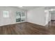 Bright living room showcasing wood-look flooring, a large window, and a neutral color palette at 203 E Lakeview Ave, Eustis, FL 32726