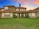 Backyard view of the house at sunset showcasing the yard and architecture at 2209 Callaway Ct, Davenport, FL 33837