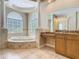 Bathroom with a large tub, columns, tiled floor and an elegant vanity at 2209 Callaway Ct, Davenport, FL 33837