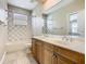 Bathroom showcasing double sinks with marble counters and a tiled shower-tub combination at 2209 Callaway Ct, Davenport, FL 33837