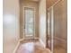 Bathroom hallway with tiled floor, framed doorway with door, and a tiled shower with glass door at 2209 Callaway Ct, Davenport, FL 33837