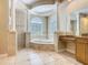 Bathroom with a large tub, columns, tiled floor and an elegant vanity at 2209 Callaway Ct, Davenport, FL 33837