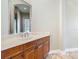 Bathroom vanity with marble countertop, wooden cabinets, and a framed mirror over the sink at 2209 Callaway Ct, Davenport, FL 33837