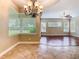 Well-lit dining area with large windows and an elegant chandelier, flowing into the living room at 2209 Callaway Ct, Davenport, FL 33837