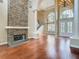 An interior view of a living room featuring a stone fireplace, hardwood floors, and a staircase at 2209 Callaway Ct, Davenport, FL 33837