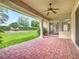 Covered patio with brick flooring, ceiling fan, and view of the landscaped backyard at 2209 Callaway Ct, Davenport, FL 33837