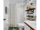Bright bathroom with a white tiled shower/tub combination and decorative shelving at 2235 Meadowmouse St, Orlando, FL 32837