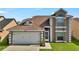 Close-up of a two-story home with a two-car garage and front lawn at 2235 Meadowmouse St, Orlando, FL 32837