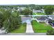Aerial view of home featuring a well-manicured lawn, mature landscaping, and long driveway at 253 Churchill Ct, Kissimmee, FL 34758