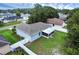 Aerial view of backyard featuring a well-manicured lawn, mature landscaping, and screened patio at 253 Churchill Ct, Kissimmee, FL 34758