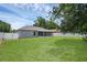 Well-maintained backyard featuring lush green grass, white fencing, and a screened in patio at 253 Churchill Ct, Kissimmee, FL 34758