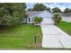 Charming home featuring a well-manicured lawn, mature palm trees, and a paved driveway at 253 Churchill Ct, Kissimmee, FL 34758