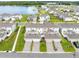Aerial view of townhomes, lush landscaping, and a serene lake in a vibrant community at 3099 Ella Way, St Cloud, FL 34771