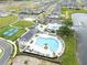 Aerial view of resort-style community pool, clubhouse, tennis courts, and playground at 3099 Ella Way, St Cloud, FL 34771