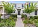 Attractive townhome with beautiful landscaping, a brick walkway, and a charming entrance, enhancing curb appeal at 3099 Ella Way, St Cloud, FL 34771