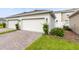 Three-car garage with brick paver driveway and professional landscaping at 3099 Ella Way, St Cloud, FL 34771