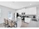 Modern kitchen with white cabinetry, stainless steel appliances, an island with bar seating and quartz countertops at 3099 Ella Way, St Cloud, FL 34771