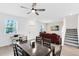 Open-concept living space with modern furnishings, a dining area, and access to the staircase, providing easy flow at 3099 Ella Way, St Cloud, FL 34771